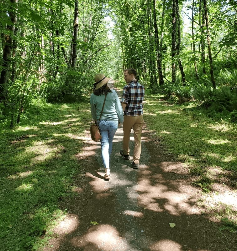 Nate Bauer and his wife walking down a forest path