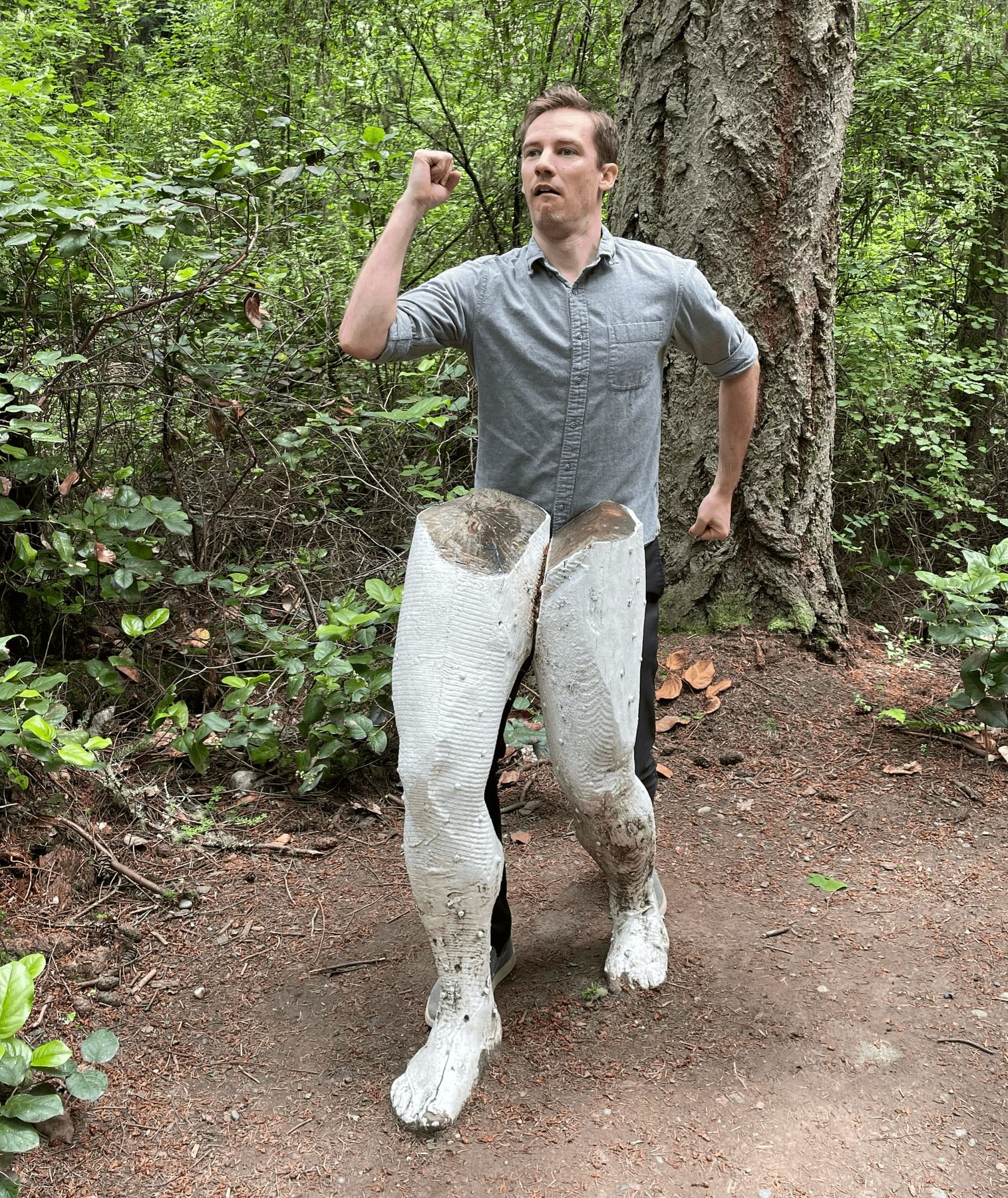 Nate Bauer posing behind a statue so the statue's legs appear to be his own