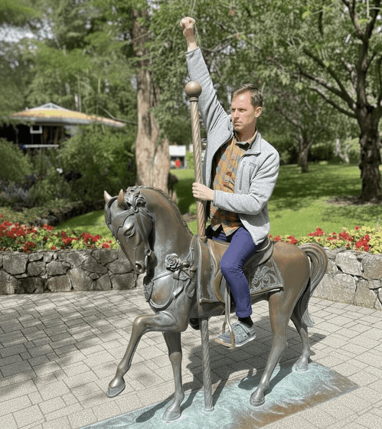 Nate Bauer mock-charging into battle on a horse statue